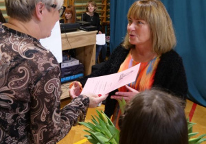 Pani Dyrektor wręcza nauczycielowi nagrodę za długoletni staż pracy.