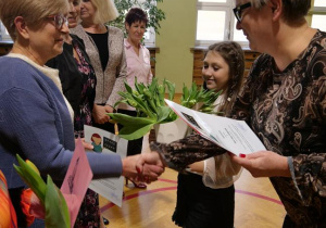 Pani Dyrektor wręcza nauczycielowi nagrodę za długoletni staż pracy.