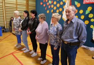 Pracownicy niepedagogiczni stoją na środku sali gimnastycznej.