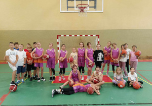 Na zdjęciu uczniowie z piłkami do kosza w sali gimnastycznej.