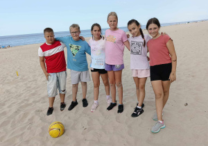Na zdjęciu uczniowie z piłką do piłki nożnej, którzy znajdują się na plaży.