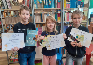 Na zdjęciu troje laureatów pokazuje dyplomy i nagrody zdobyte w konkursie.