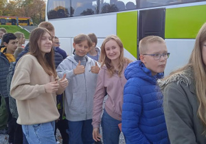 Uczniowie stoją przed autokarem.