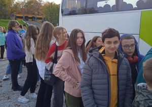 Uczniowie stoją przed autokarem.