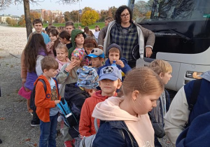 Uczniowie stoją przed autokarem.