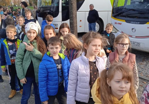 Uczniowie stoją przed autokarem.