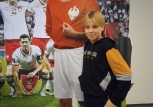Uczeń robi sobie zdjęcie z makietą piłkarza.