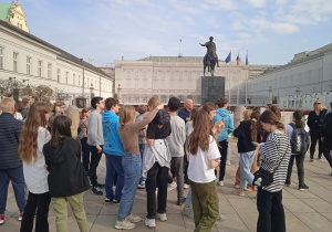 Uczniowie stoją przed Pałacem Prezydenckim.