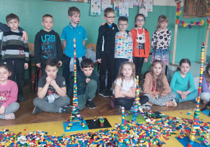 Uczniowie stoją przed wybudowanymi przez nich z klocków Lego Wieżach Eiffla.