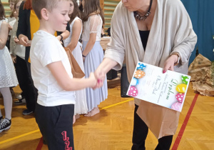 Pani Dyrektor wręcza dyplom nagrodzonej uczennicy.