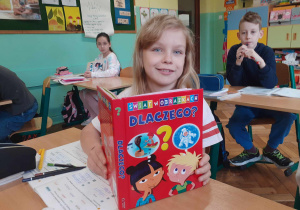 Na zdjęciu dziewczynka prezentuje ulubioną książkę.