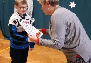 Na zdjęciu Pani Dyrektor wręcza dyplom nagrodzonemu uczniowi.