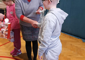 Na zdjęciu Pani Dyrektor gratluje wylosowanemu uczniowi.