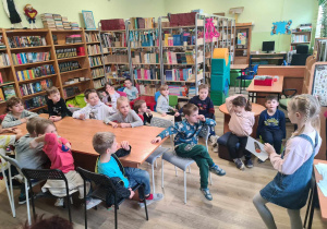 Na zdjęciu uczniowie klasy 1a rozwiązują w czytelni zagadki.