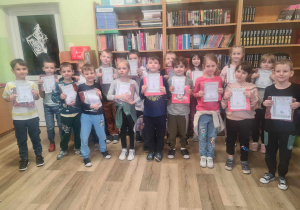 Na zdjęciu uczniowie klasy 1a, którzy trzymają w rękach dyplomy i wyprawkę czytelnika.