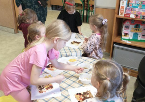 Dzieci wykonują obrazki z produktów spożywczych.