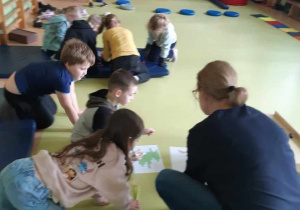 Na zdjęciu nauczycielka tłumaczy uczniom zadanie podczas warsztatów.