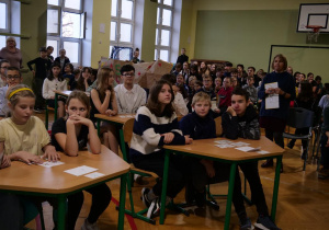 Przedstawiciele klas w sali gimnastycznej biorą udział w konkursie o Janie Kochanowskim.