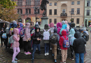 Na zdjęciu uczniowie, którzy stoją przy fontannie.