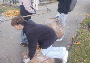 Na zdjęciu uczniowie, biorący udział w wolontariacie na cmentarzu.