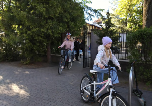 Na zdjęciu rowerzystki podjeżdżają do szkoły na rowerach.