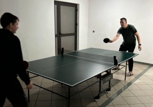 Na zdjęciu opiekun wycieczki gra w ping-pong wraz z jednym z uczestników wycieczki.