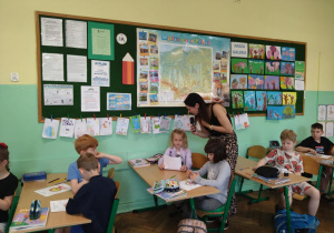 Dziennikarka Radia Łódź rozmawia w klasie z dziewczynką.