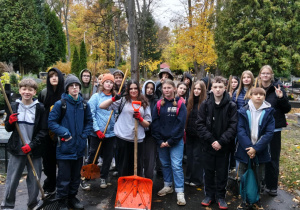 Na zdjęciu uczniowie klasy 7b podczas akcji sprzątania cmentarza.