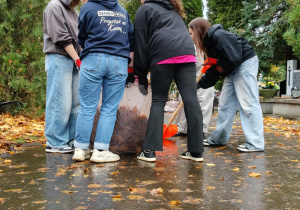 Na zdjęciu uczniowie klas 7 podczas akcji sprzątania cmentarza.