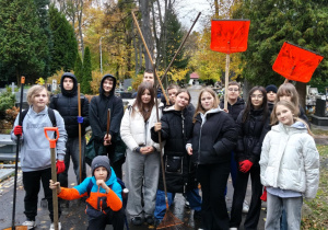 Na zdjęciu uczniowie klasy 7a podczas akcji sprzątania cmentarza.