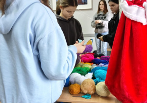 Na zdjęciu uczniowie podczas wybierania materiałów do zajęć praktycznych z wykorzystaniem przędzy.