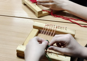 Na zdjęciu uczniowie podczas wykonywania breloczków na przędzy.