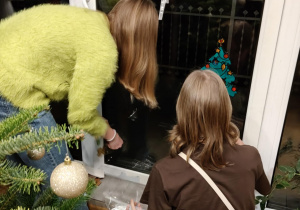 Na zdjęciu uczennice dekorują okno.
