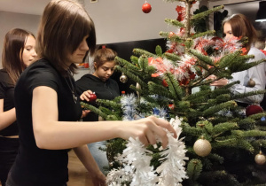 Na zdjęciu uczeniowie klasy 7b podczas dekorowania choinki.