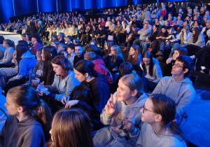 Na zdjęciu uczniowie klas 7 i 8, którzy siedzą na widowni.