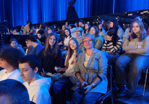 Na zdjęciu uczniowie klas 7 i 8, którzy siedzą na widowni.