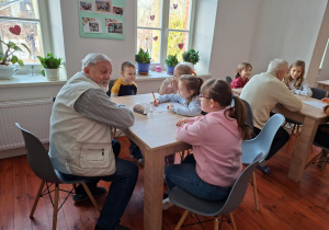 Na zdjęciu uczniowie klasy 2a prowadzą rozmowę z seniorem.