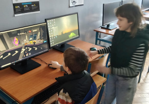 Na zdjęciu przyszłoroczni uczniowie klasy 1, którzy stoją przy kompuetrze w pracowni informatycznej.