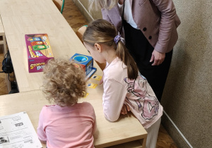 Na zdjęciu dziewczynki rozwiązują zagadki w języku angielskim.