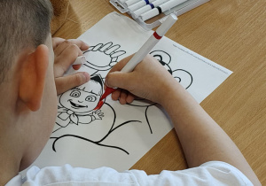 Na zdjęciu dziecko, które koloruje obrazek.