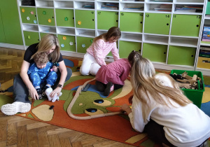 Na zdjęciu goście podczas zabaw na dywanie.