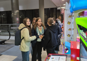 Na zdjęciu uczniowie w kinie przy automatach do gier.