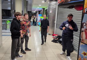 Na zdjęciu uczniowie w kinie przy automatach do gi