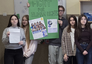 Na zdjęciu uczniowie w szkole z plakatami i listami w obronie praw ludzi.