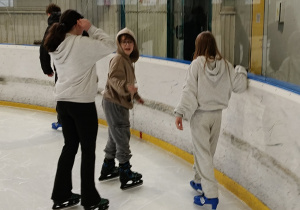 Na zdjęciu uczniowie podczas jazdy na łyżwach na lodowisku.