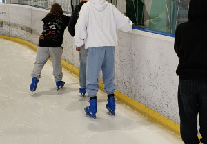 Na zdjęciu uczniowie podczas jazdy na łyżwach na lodowisku.