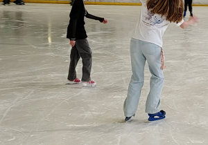 Na zdjęciu uczniowie podczas jazdy na łyżwach na lodowisku.