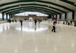 Na zdjęciu uczniowie podczas jazdy na łyżwach na lodowisku.
