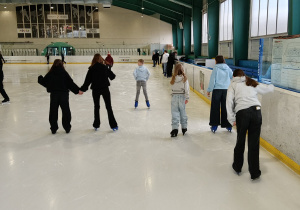 Na zdjęciu uczniowie podczas jazdy na łyżwach na lodowisku.