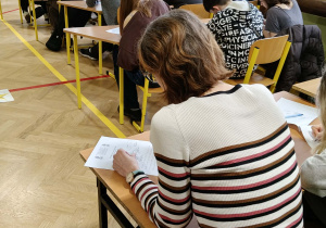 Na zdjęciu uczestnicy dyktanda piszą tekst.